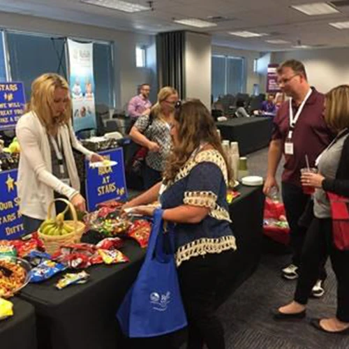 Image of people visting the vendors' tables at a conference.